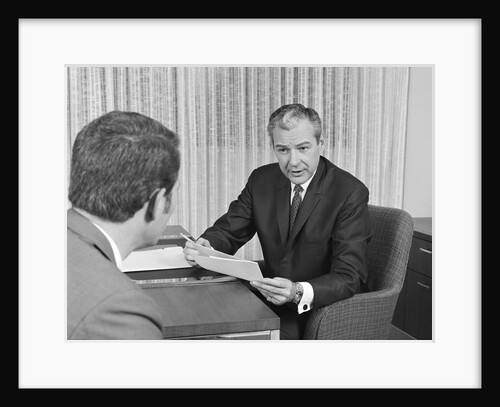 Man from behind meeting at desk of older businessman by Anonymous