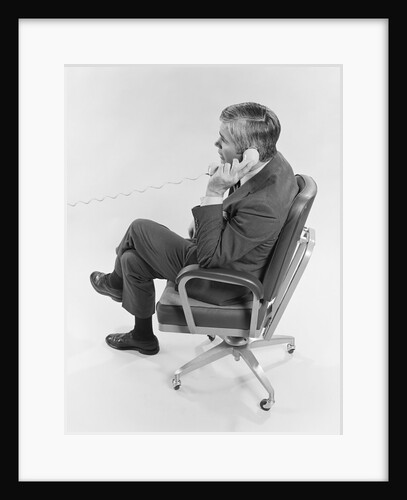 Profile executive businessman sitting in office chair talking on telephone by Anonymous