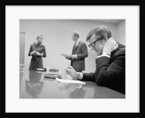 Worried businessman seated conference table two people in background by Anonymous
