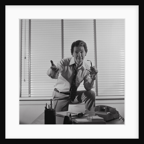 Businessman standing behind desk arm raised in pleading gesture by Anonymous
