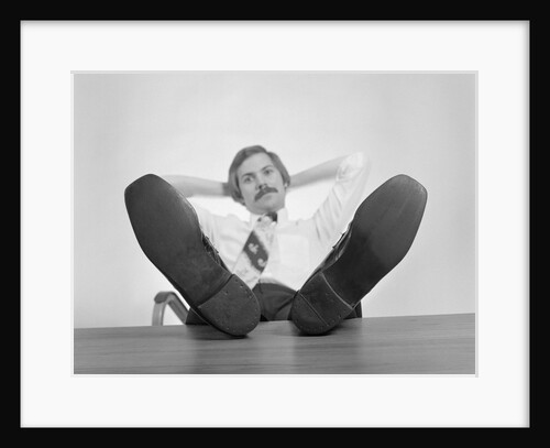 Businessman sitting feet up on desk by Anonymous