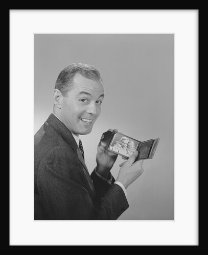 Man smiling holding wallet showing photo of family by Anonymous
