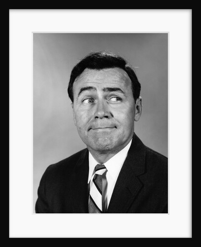 Businessman making funny face looking to the side by Anonymous