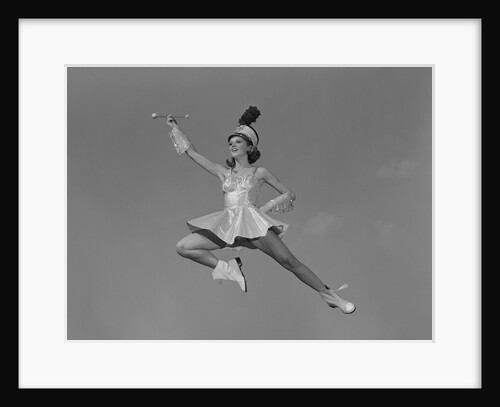 Woman majorette holding baton wearing short skirt uniform jumping into the air by Anonymous