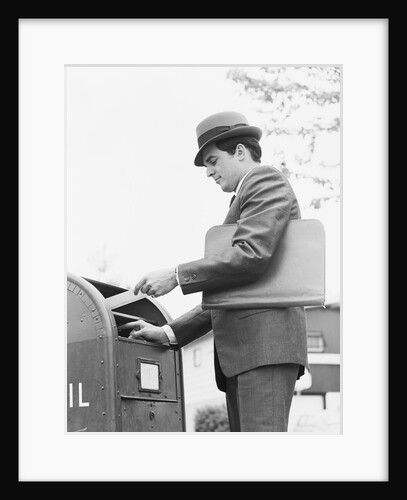 Young businessman with briefcase dropping letter into mailbox by Anonymous