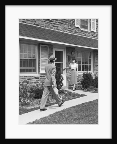 Man coming home down sidewalk woman waiting at door by Anonymous