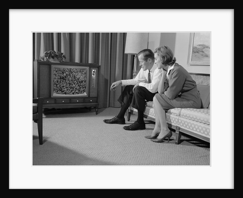 Couple man woman sitting on couch watching television by Anonymous