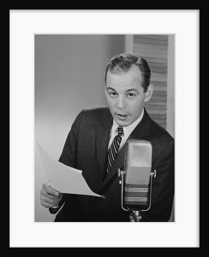 Serious man speaking into microphone holding papers newsman announcer broadcaster by Anonymous