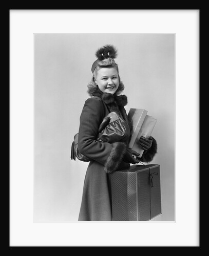 Smiling young blond woman wearing hat fur trimmed coat carrying packages by Anonymous