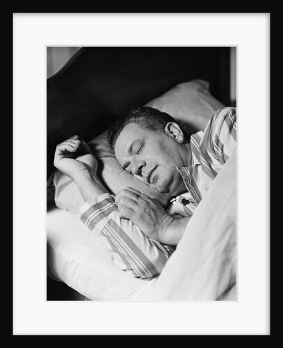 Man asleep sleeping in bed wearing pajamas by Anonymous