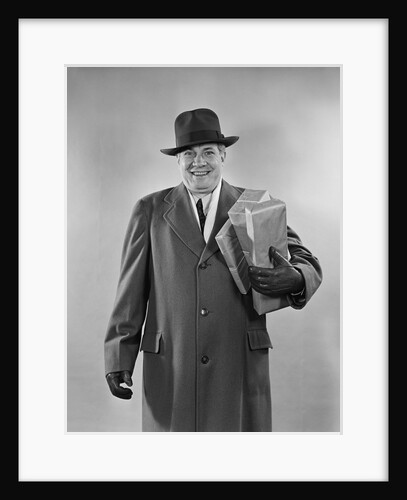 Smiling man carrying shopping boxes wearing hat coat gloves by Anonymous