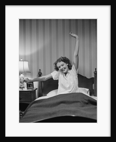Young woman in bed stretching waking up by Anonymous