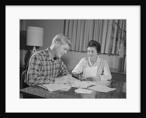 Couple man woman at table working on household accounts bills by Anonymous