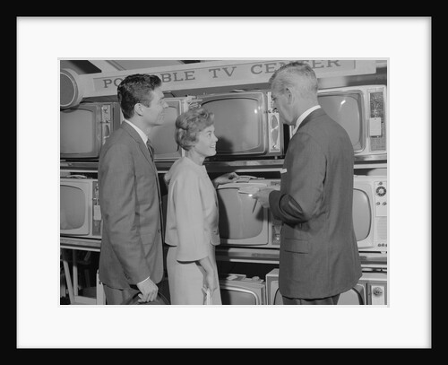 Couple shopping for portable tv being helped by salesman by Anonymous