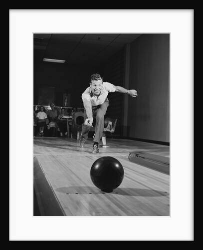 Man releasing ball down bowling alley lane by Anonymous