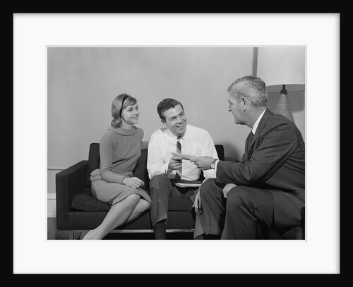 Couple sitting on couch talking to salesman by Anonymous