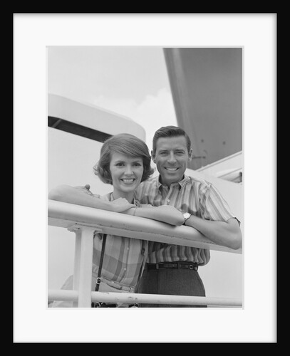 Portrait smiling couple standing by shipboard rail by Anonymous