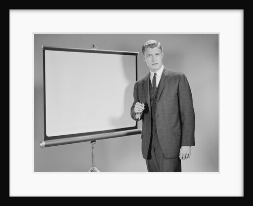 Man standing beside blank screen ready for presentation by Anonymous