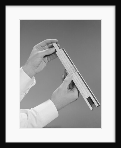 Male hands holding a slide rule measure by Anonymous