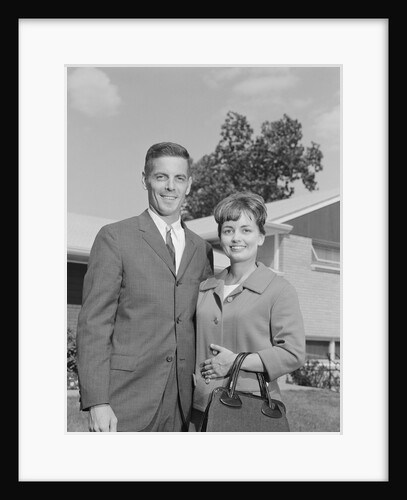 Portrait smiling couple in front of suburban house by Anonymous