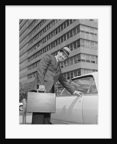 Businessman carrying briefcase getting into car on urban street by Anonymous