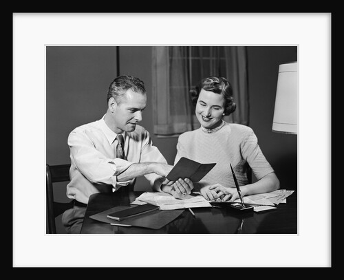 Couple man woman smiling looking at banking savings passbook at home desk by Anonymous