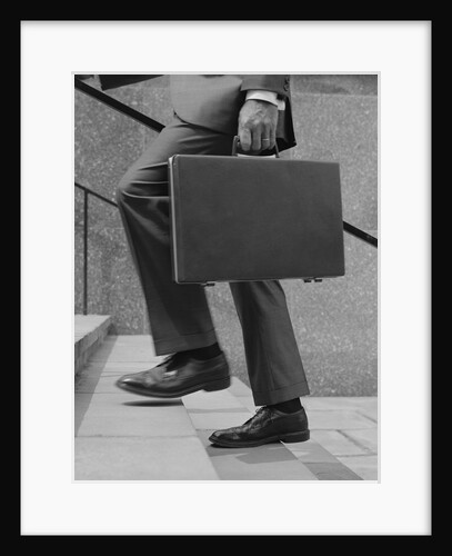 Businessman legs walking up stairs hand holding briefcase by Anonymous