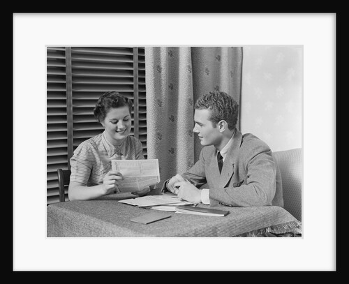 Couple man woman sitting at table going over papers by Anonymous
