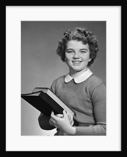 Adolescent teen girl smiling portrait holding school books by Anonymous