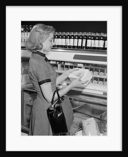 Blond woman selecting ice cream frozen food section supermarket by Anonymous