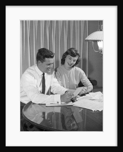 Couple husband wife dining table going over household accounts by Anonymous
