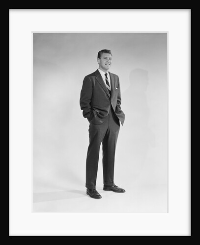 Portrait smiling man standing with hands in pockets wearing suit and tie by Anonymous