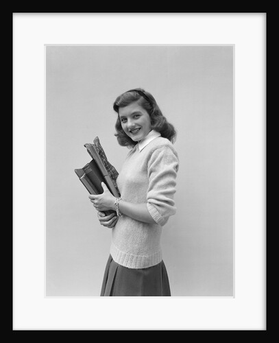 Smiling brunette teen student wearing sweater carrying school books by Anonymous