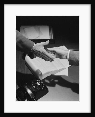 Close-up two male hands about to shake over desk with papers and telephone by Anonymous