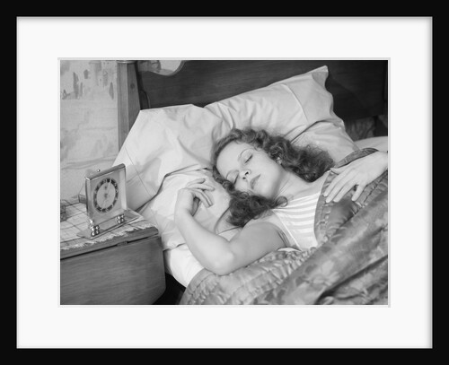 Woman sleeping asleep in bed alarm clock on night table by Anonymous