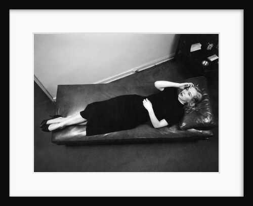 Worried woman hand to forehead seen from above lying down on psychiatrist therapy couch by Anonymous