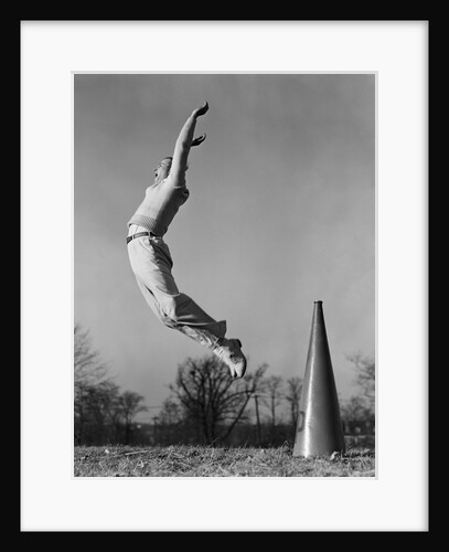 Male cheerleader jumping cheering megaphone on ground by Anonymous