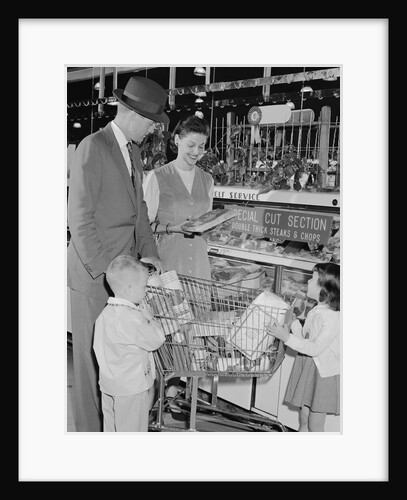 Family of 4 inside supermarket father pushing cart mother 2 kids by Anonymous
