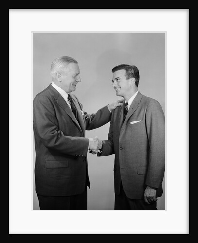 Older and younger business men shaking hands by Anonymous