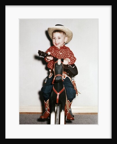 Little boy cowboy plays guitar while riding his horse, ca. 1956 by Anonymous