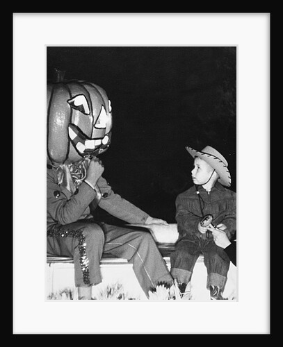 Young boy warily eyes pumpkin man, ca. 1955 by Anonymous