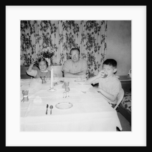 Father with children at the dinner table, ca. 1962 by Anonymous