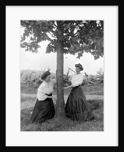 Two women chase each other around a tree, ca. 1910 by Anonymous
