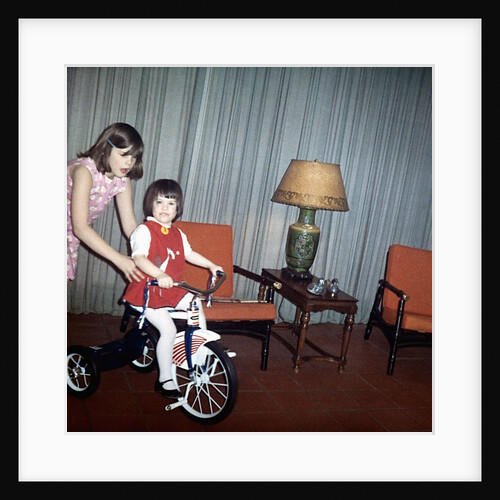 Older sister helps her sister with new bike, ca. 1967. by Anonymous