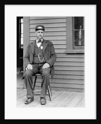 Station master sits at the train depot, ca. 1900. by Anonymous