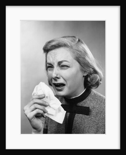 1950s woman with handkerchief sneezing indoor by Anonymous
