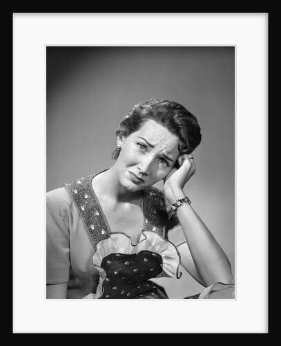 1950s housewife woman in print apron hand up to temple headache pain sad depressed facial expression worried serious looking at camera by Anonymous