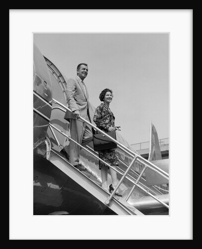 1950s couple exiting plane steps by Anonymous