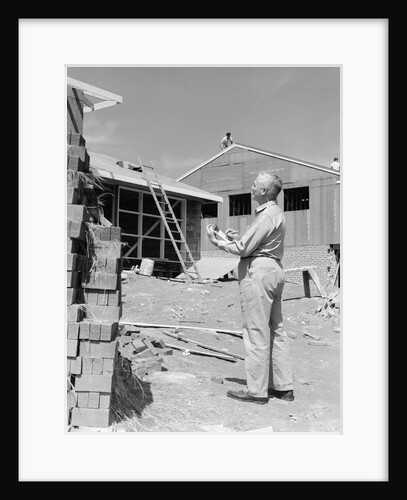 1950s senior man with clipboard on construction site by Anonymous