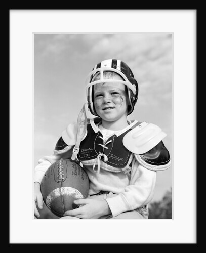 1960s boy in football helmet and pads holding ball smiling outdoor by Anonymous